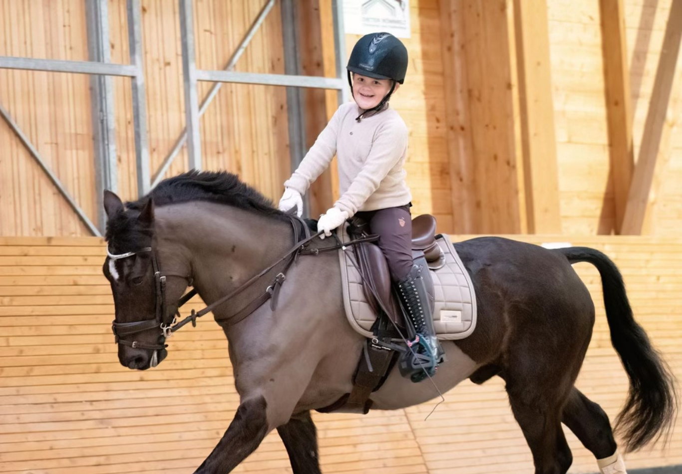 A kid riding a horse with the brown pony size Correct Connect Double Neck Strap